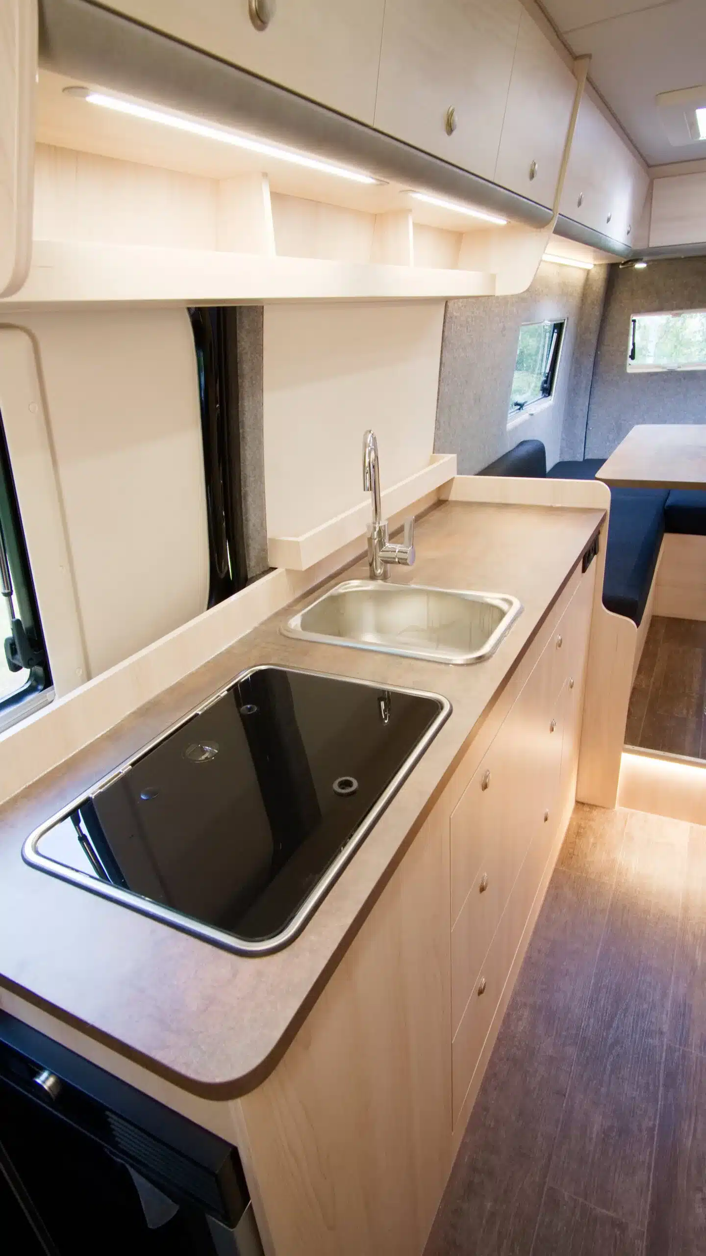 Küchenbereich mit Spüle, Kochfeld und Stauraum im Bresler 694 U Campervan