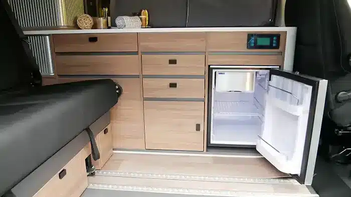 Innenansicht der Küchenzeile mit offenem Kühlschrank im Mooveo CAMPERVAN 3
