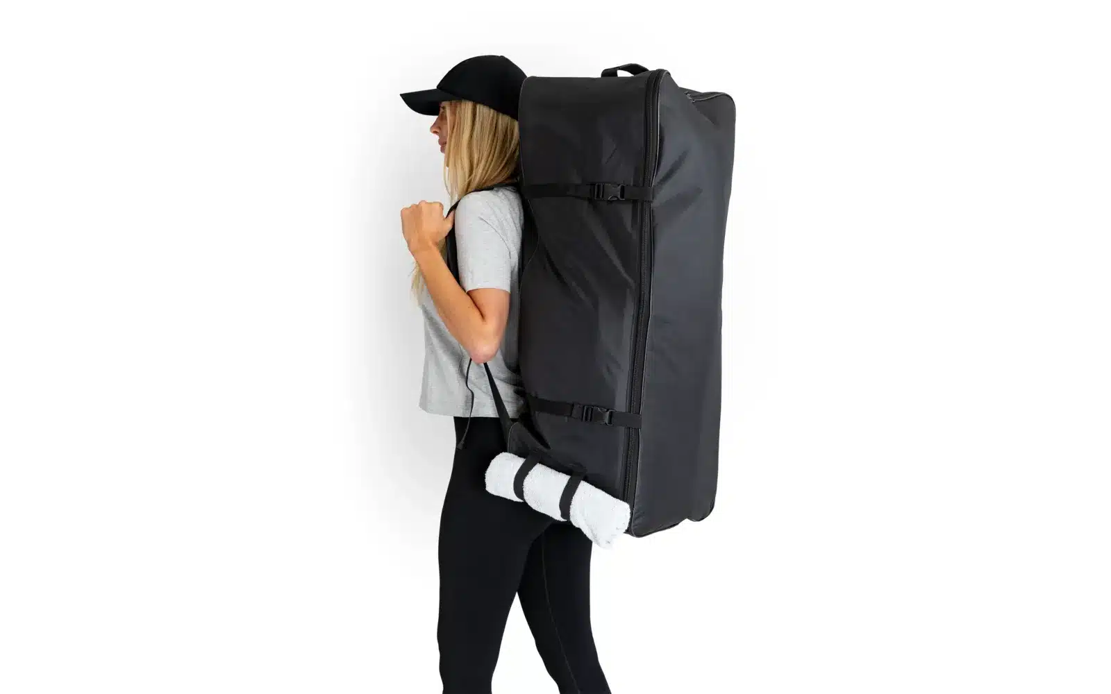 Frau trägt eine große schwarze Transporttasche auf dem Rücken, passend für das Camptime SUP-Board Set.