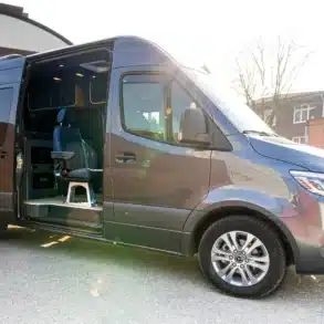 Außenansicht eines modernen Sprinter Mixto mit geöffneter Schiebetür und sichtbarem modularen Innenausbau.