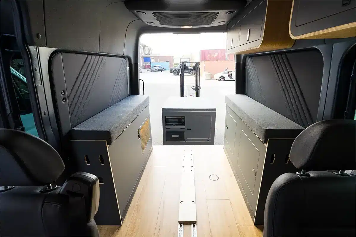 Innenraum eines Sprinter Mixto mit modularen Möbeln und entnehmbarem Heckmodul, Blick aus dem Heck.