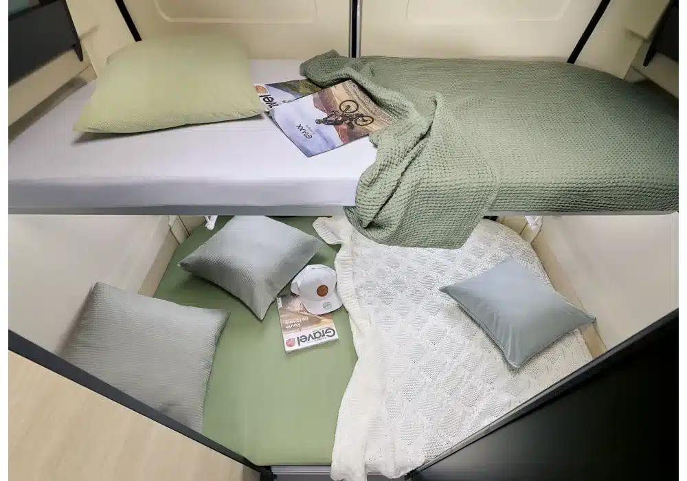 Innenansicht des Dreamer Camper Five mit zwei Schlafbereichen, Bettwäsche und Kissen.