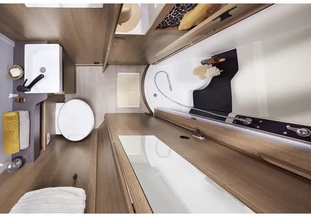 Modernes Bad mit Toilette, Waschbecken und getrennter Dusche im Dreamer Camper Van XL Saphir, fotografiert von oben.
