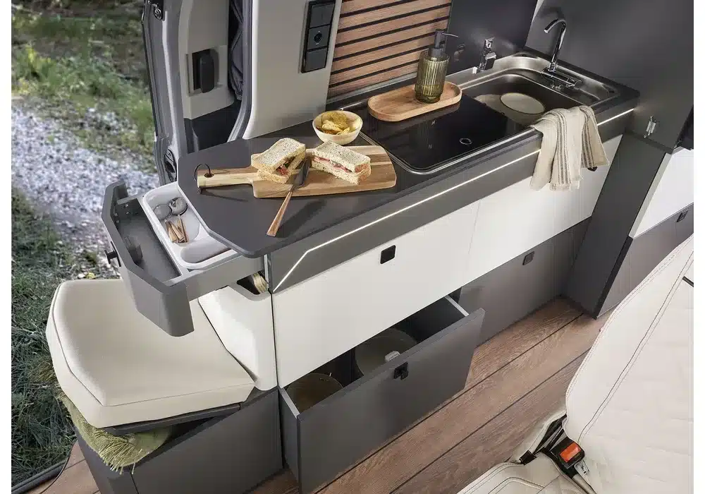 Innenansicht der Küchenzeile und Sitzbank im kompakten Dreamer Cap Land Campervan