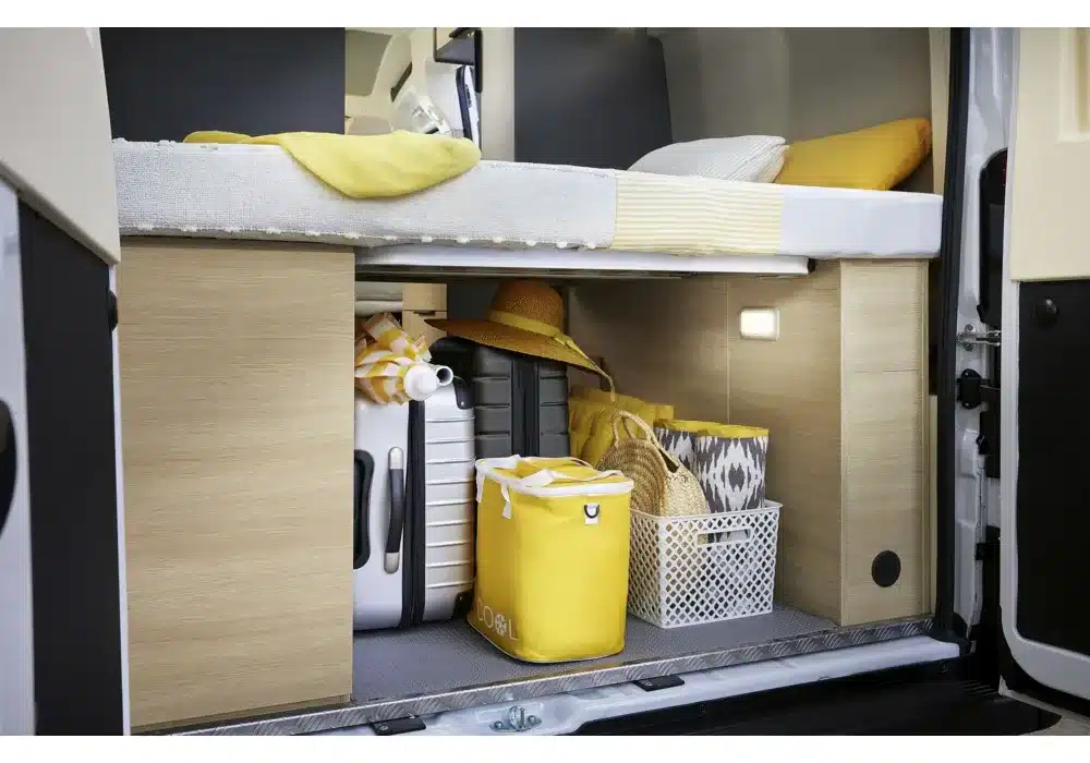 Stauraum unter einem feststehenden Bett im Kastenwagen Dreamer D43 UP, befüllt mit Gepäck und Campingausstattung