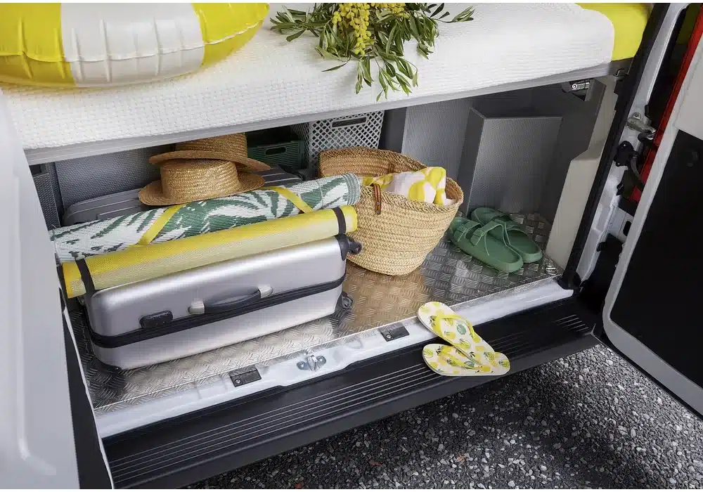Stauraum im Dreamer D43 UP Select Campervan, bepackt mit Koffer, Korb, Matte und Flip-Flops
