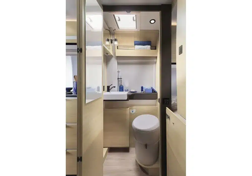 Innenansicht des Badezimmers mit WC, Waschbecken und Stauraum im Dreamer D55 Kastenwagen.