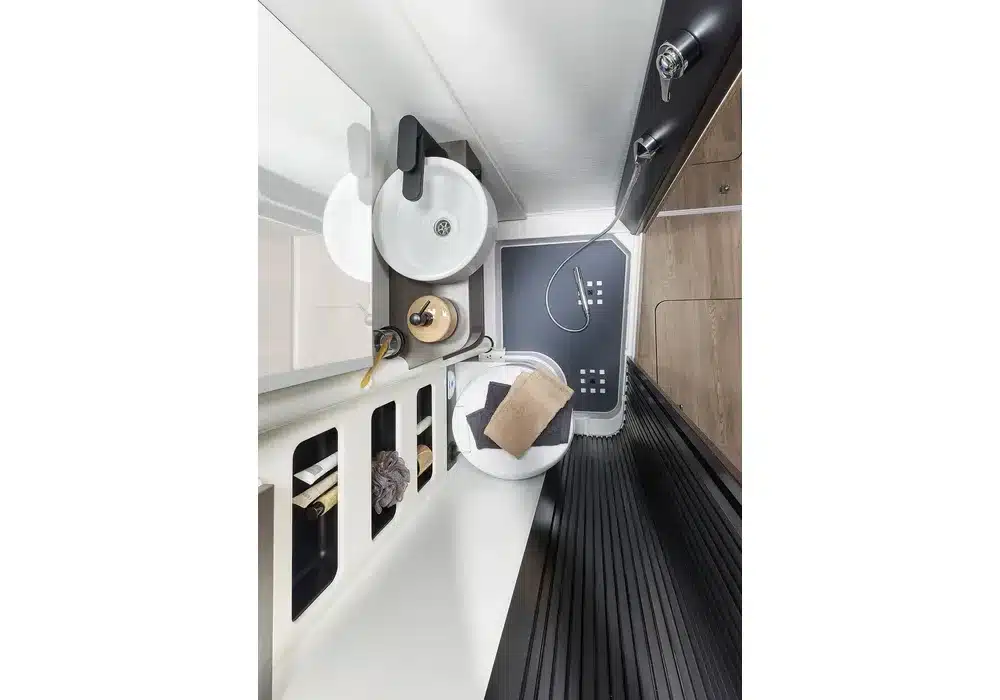 Badezimmer mit schwenkbarer Wand, Waschbecken, WC und Dusche im Dreamer Family Van.