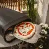 Enders Paco Rotate Pizzaofen gasbetrieben mit rotierendem Pizzastein und Pizza auf Schaufel vor dem Ofen