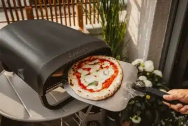 Enders Paco Rotate Pizzaofen gasbetrieben mit rotierendem Pizzastein und Pizza auf Schaufel vor dem Ofen