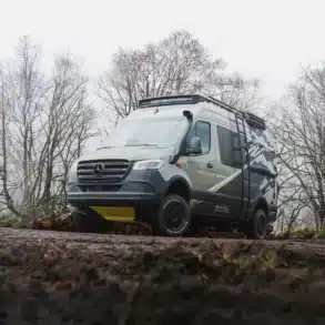 Hispaniola 4x4 Campervan, aufgebaut auf Mercedes-Benz Sprinter, steht fahrbereit auf einer schlammigen Waldpiste.