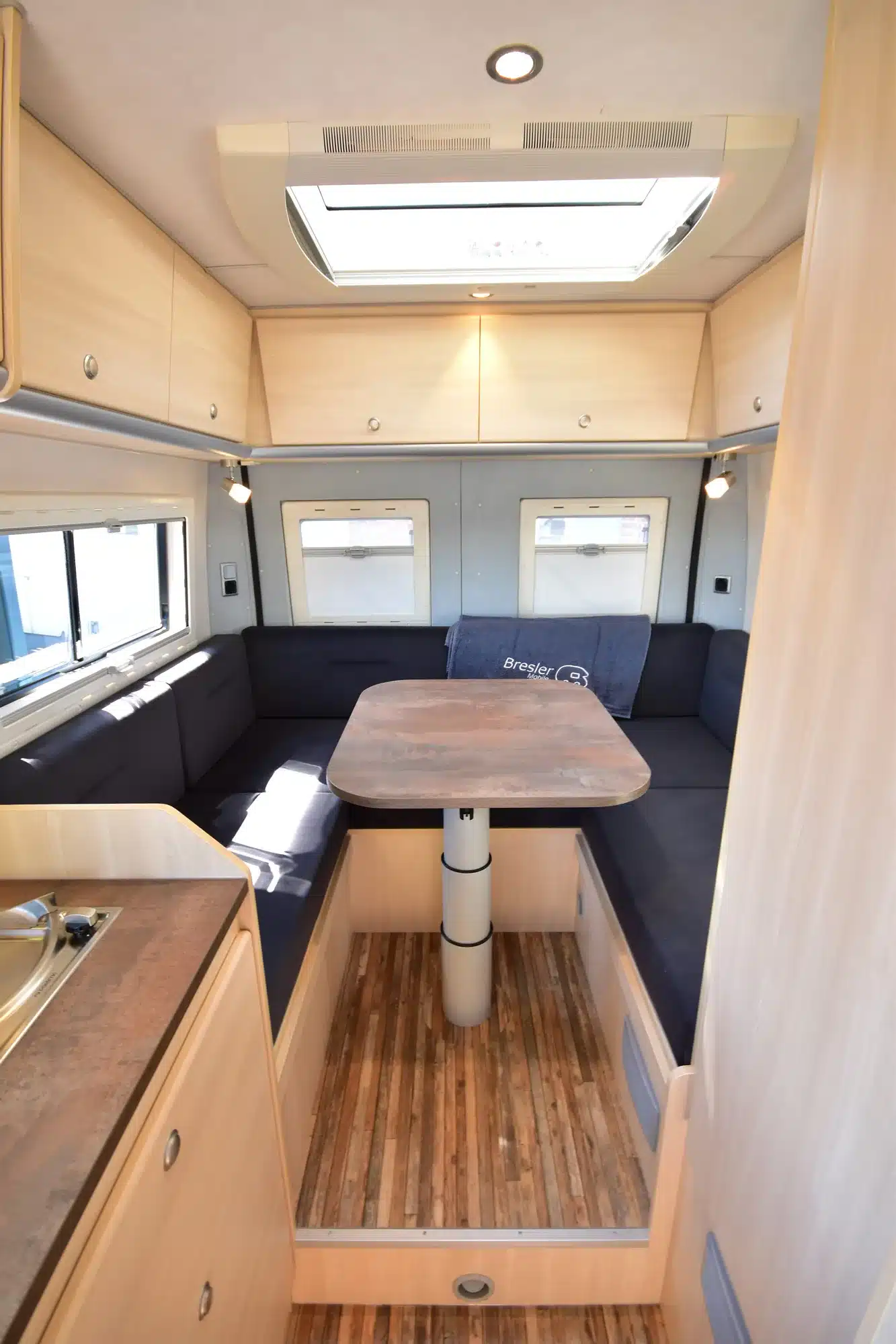 U-Sitzgruppe im Heck des Horizont 541 U Campervans mit großen Fenstern und hellem Holzdekor.