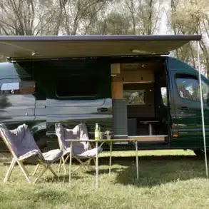 Hulk Campervan auf Mercedes-Benz Sprinter 419 4x4 mit Markise und Campingmöbeln im Freien