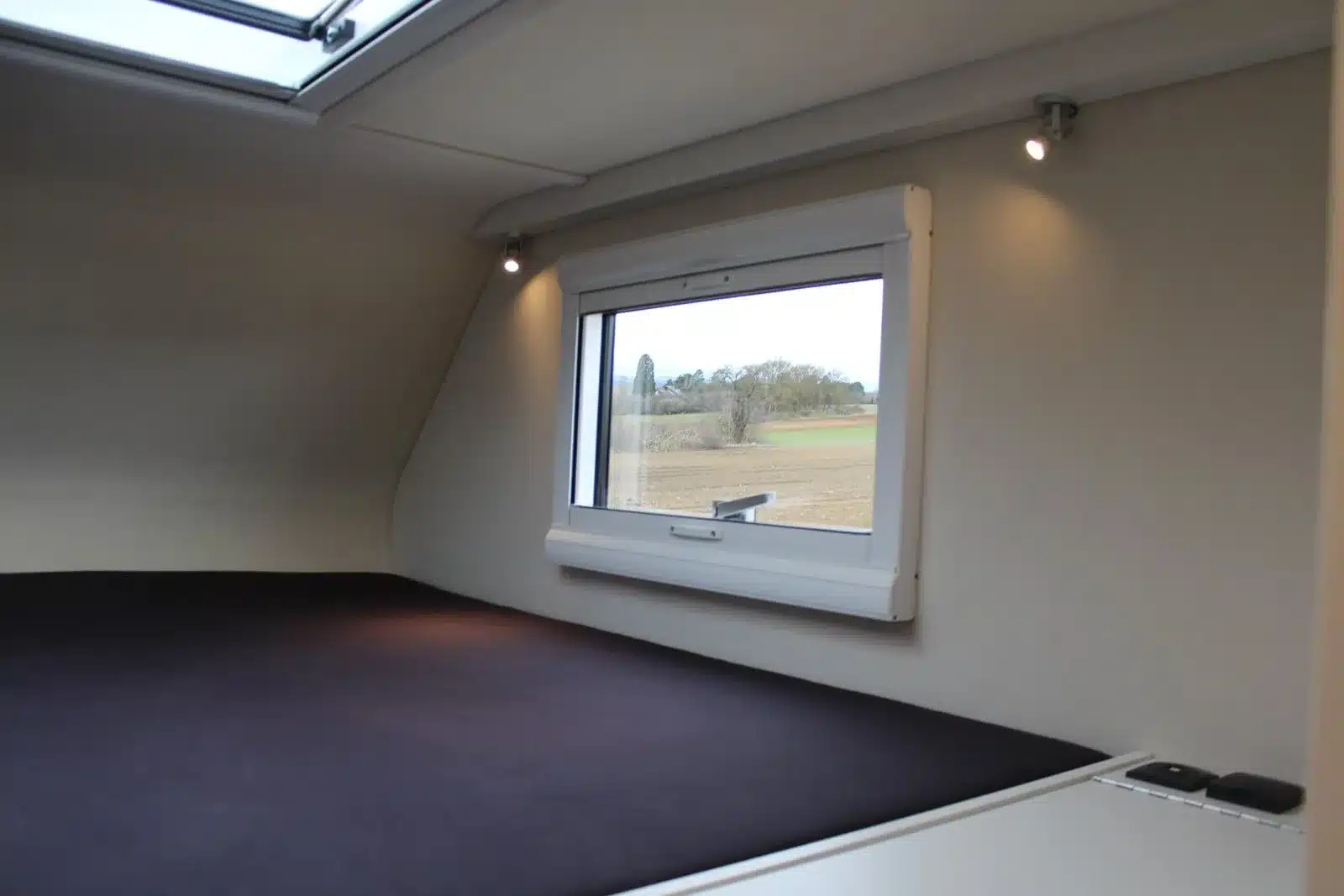 Schlafbereich mit Fenster und Dachluke im Woelcke Wohnaufbau eines Iveco Daily 4x4 Achleitner.