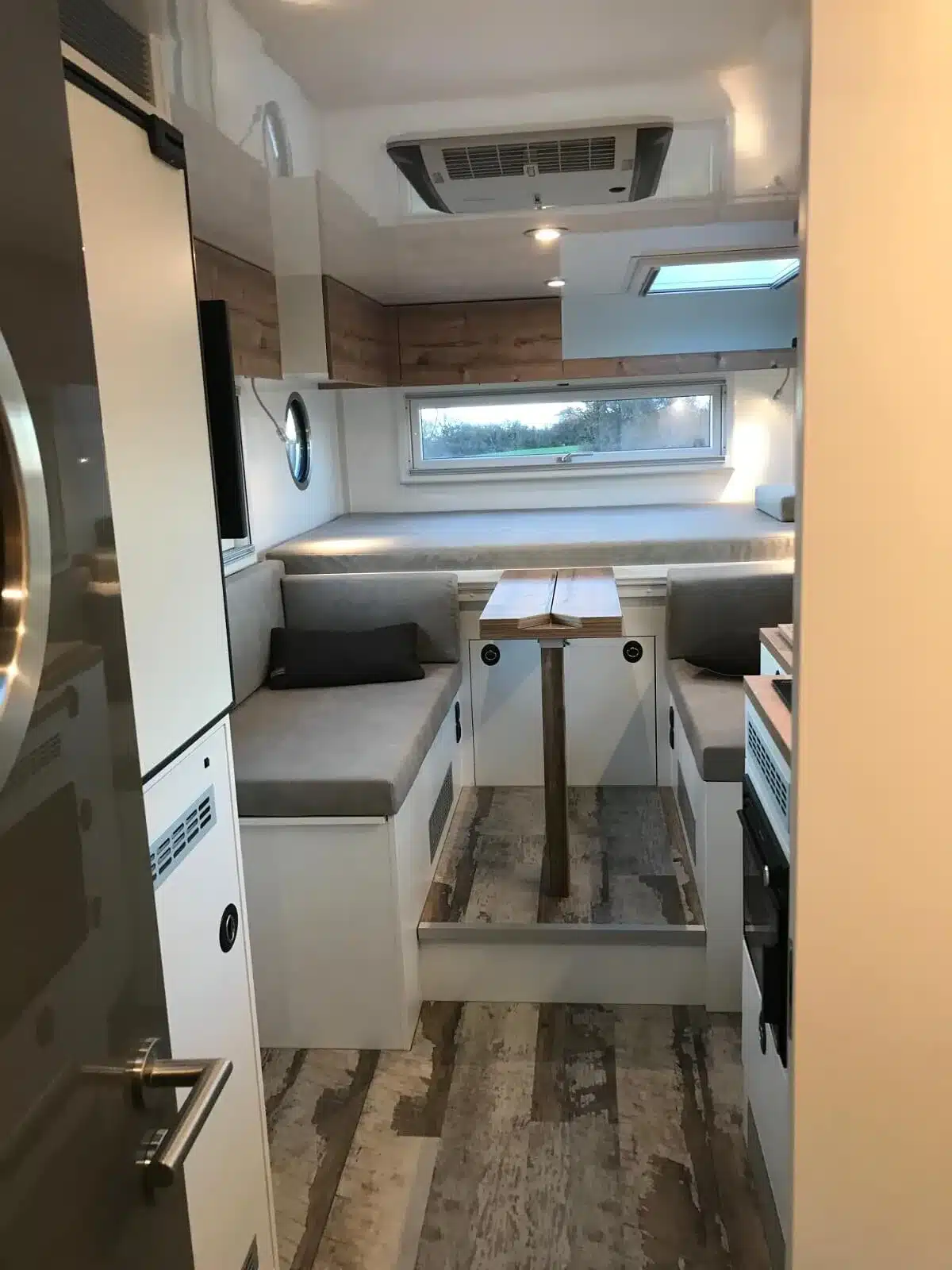 Sitzgruppe und Wohnbereich im Innenraum eines Woelcke GFK-Wohnaufbaus im Iveco Daily 4x4
