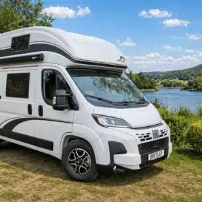 Der BRESLER JUNIOR 541 DK-F Kastenwagen steht auf einer Wiese vor einem See, umgeben von Natur und Bäumen.