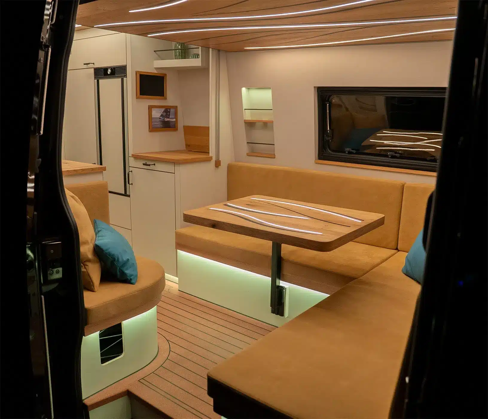 Blick in den stilvoll eingerichteten Wohnbereich des Mercedes Sprinter La Onda Campervans mit Wellenmotiv und LED-Beleuchtung