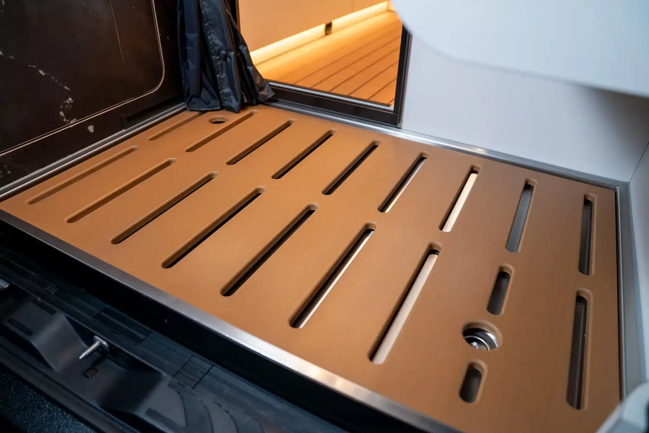 Detailaufnahme des Dutch Vanparts Multiflexboards in der Heckgarage des Mercedes-Benz Sprinter La Onda Campervans.