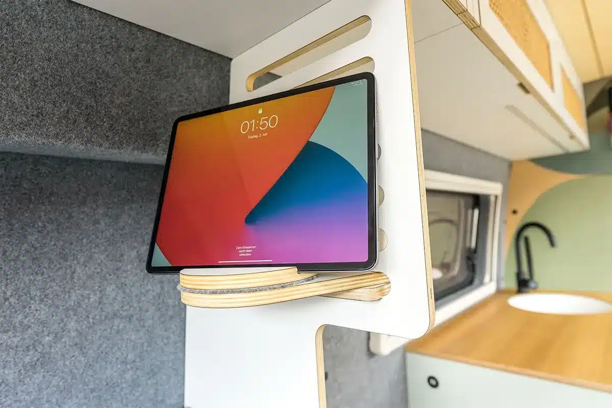 Detailaufnahme einer Tablet-Halterung im Campervan Libelle, mit Küchenbereich im Hintergrund.