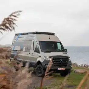 Offroad-Campervan Major Monster Mercedes-Benz Sprinter 4x4 am Ufer mit Natur im Vordergrund