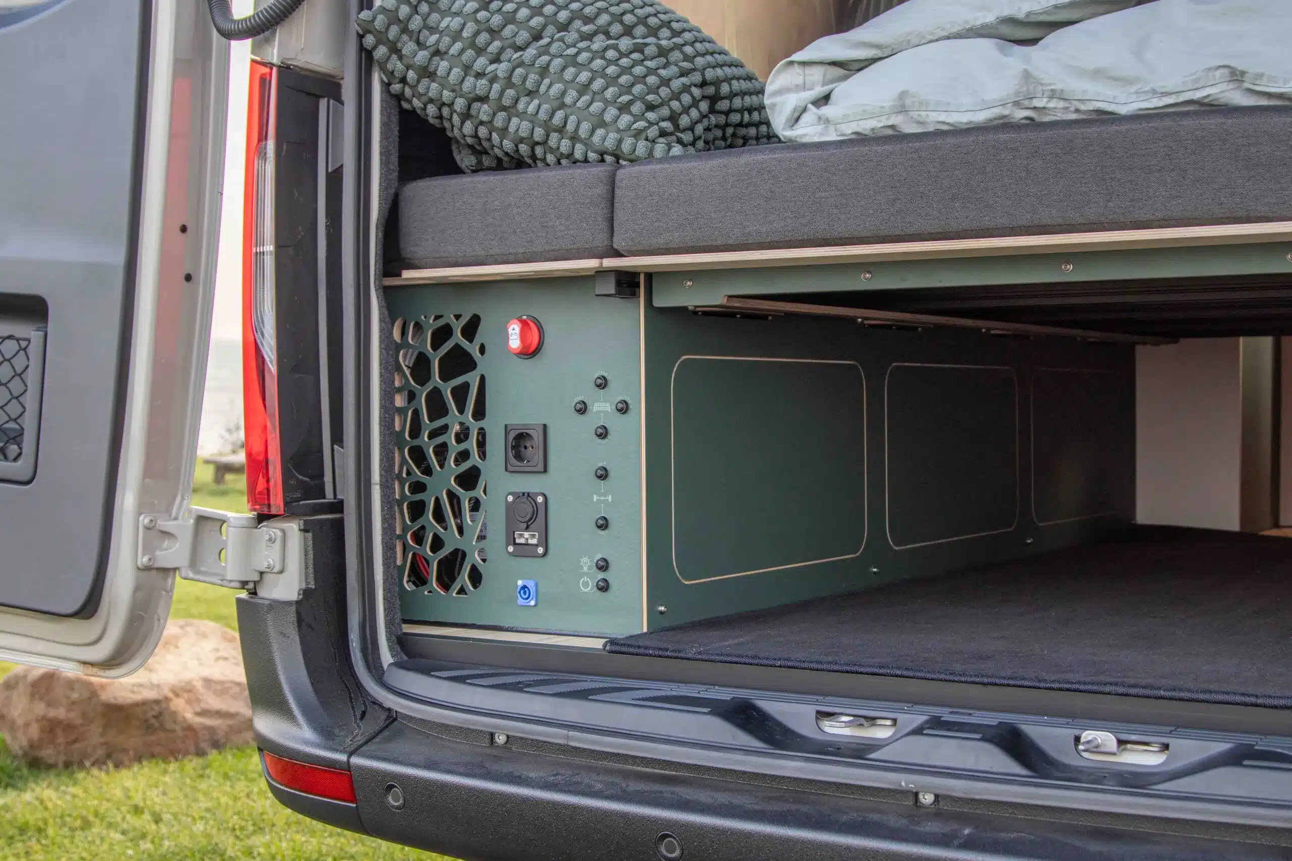 Blick auf das Heck des 4x4-Camper Major Monster mit Stauraum und elektrischen Anschlüssen unter dem Bett