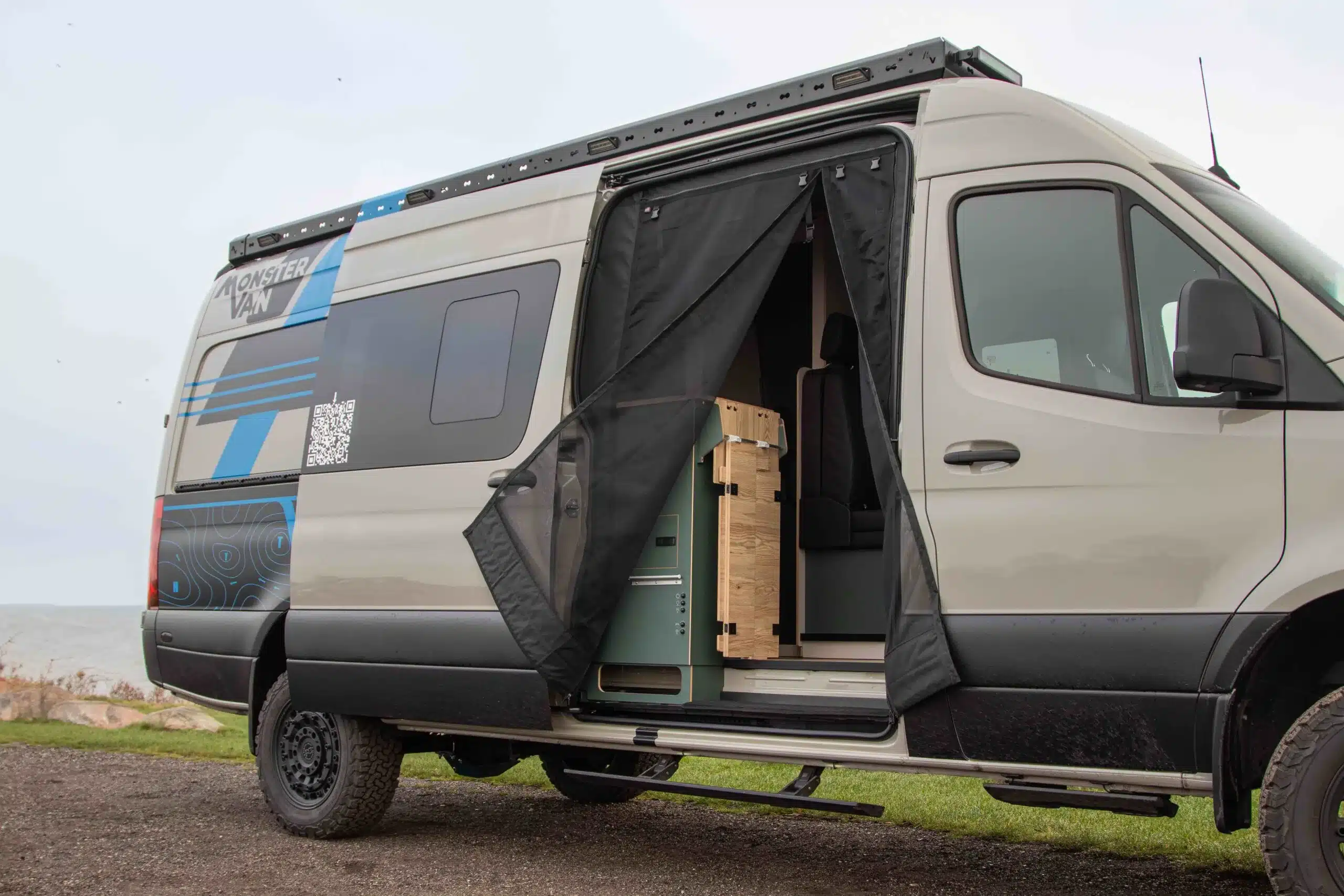 Außenansicht des Major Monster 4x4 Campervans mit geöffneter Schiebetür und sichtbarem Innenausbau.