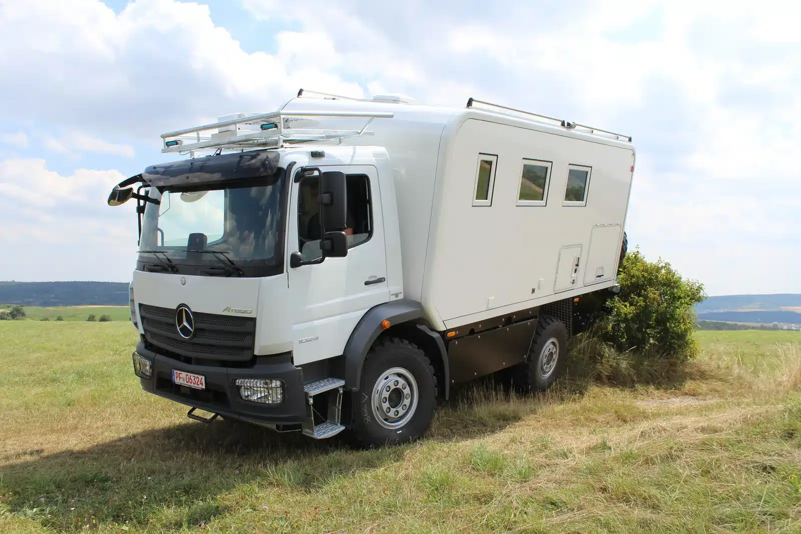 Mercedes-Benz Atego 1023 A 4x4 Expeditionsmobil auf einer Wiese, geeignet für autarkes Reisen und Wintertouren