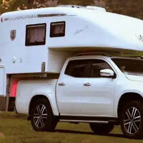 Pick-up mit absetzbarer Mono 4x4 Wohnkabine und Camper-Gruppe im Grünen