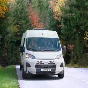 Weißer MOOVEO VAN 60DB fährt auf einer schmalen Waldstraße