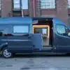 Morinter Campervan auf Basis eines Mercedes-Benz Sprinter, Seitenansicht mit weit geöffneter Schiebetür, Innenraum sichtbar.