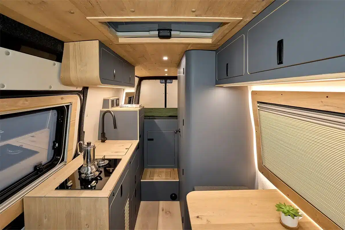 Moderner und heller Innenraum eines Morinter Campervans mit Echtholzfurnier, Küche, Ober- und Unterschränken sowie funktionalem Grundriss.