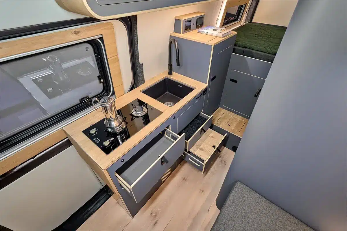 Küchenzeile, Spüle und Stauraum im Morinter-Sprinter-Campervan mit Echtholzfurnier und offenem Schubladensystem