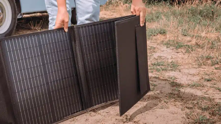 Person stellt ein faltbares Solarmodul MSFO-200 im Freien für den Betrieb auf.
