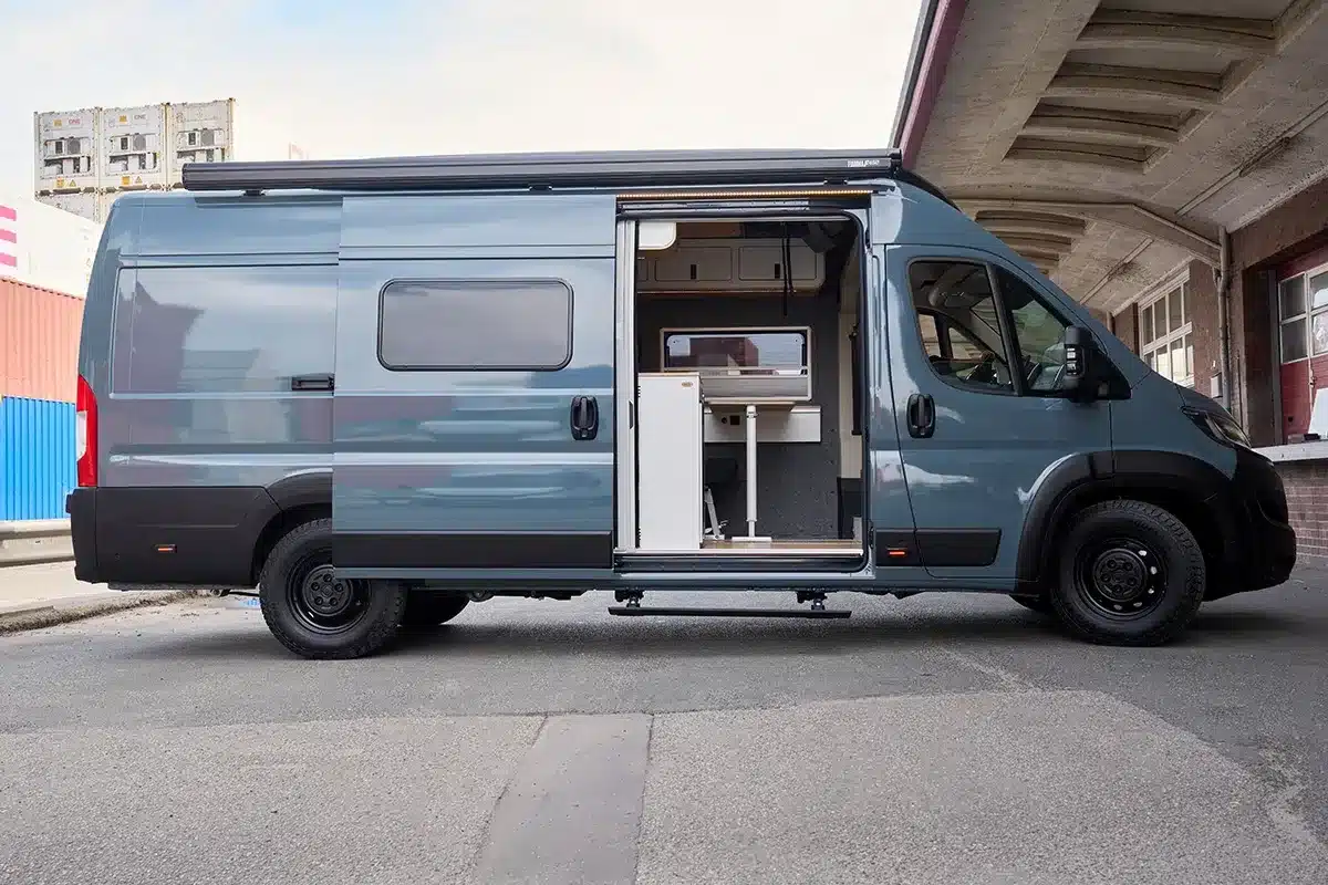 Seitenansicht des Multi Racer Campervans auf FIAT Ducato Basis mit offener Schiebetür und sichtbarem Innenausbau.