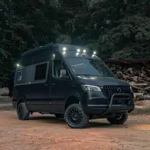 Noah Pulse Campervan auf Mercedes-Benz Sprinter, mit Offroad-Bereifung und Dachbeleuchtung, parkend am Waldrand.