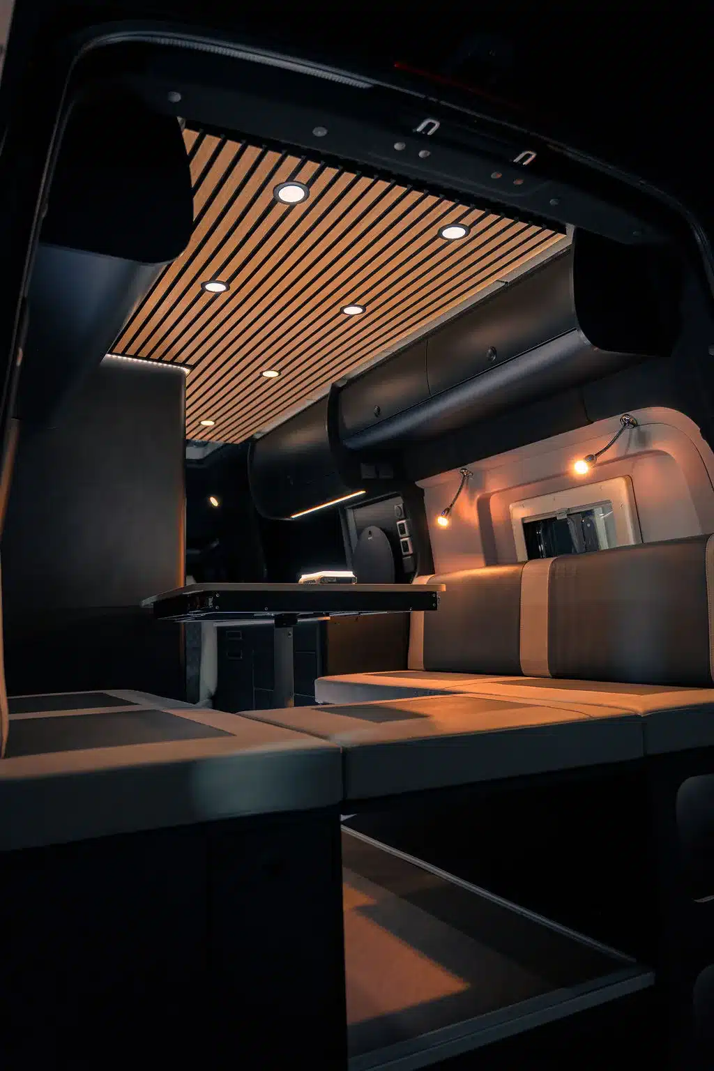 Innenraum des Noah Pulse Campervans mit Dinette, Tisch, moderner Holzdecke und LED-Spots.