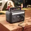 Mestic MPS-300 Powerstation mit angeschlossenem Kabel auf Holzoberfläche in einem Campingumfeld