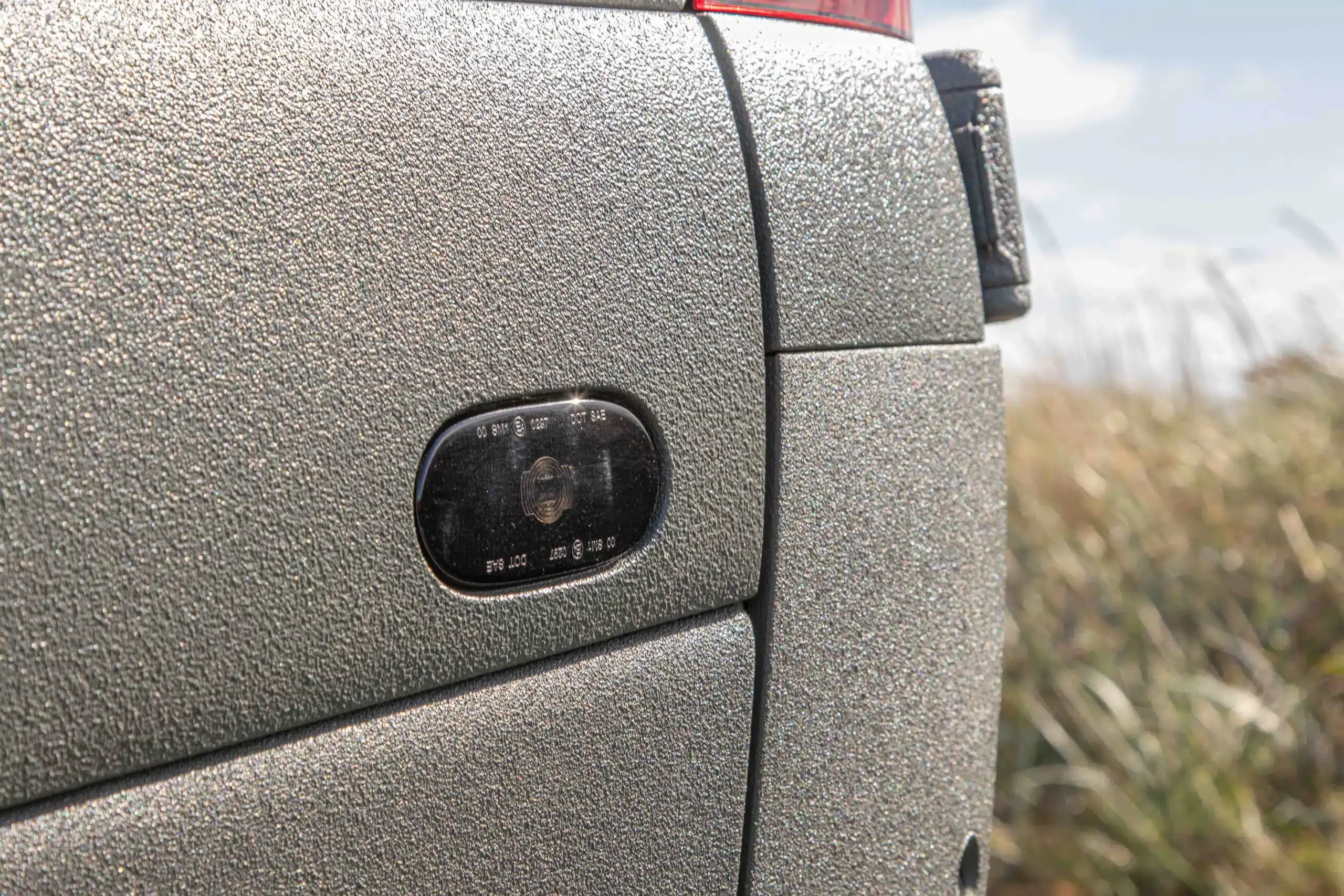 Nahaufnahme der strukturierten Raptor-Lackierung am Mercedes-Benz Sprinter SONIC MONSTER