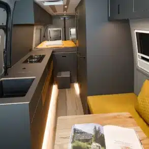 Hochwertig ausgebauter Innenraum des VANME Straight Edge Campervans mit Küche, Lounge und Querbett.