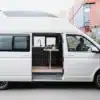 Seitenansicht des Streamline XL Campervans auf VW T6.1 Basis mit geöffnetem Hochdach und Einblick in den Innenraum mit Küchenzeile und Tisch.