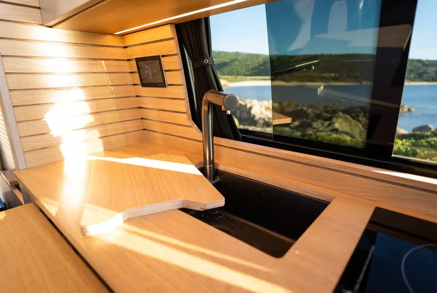 Küchenzeile aus Echtholz mit Spüle im Innenraum des VW T6.1 Expedition Pro Campervans