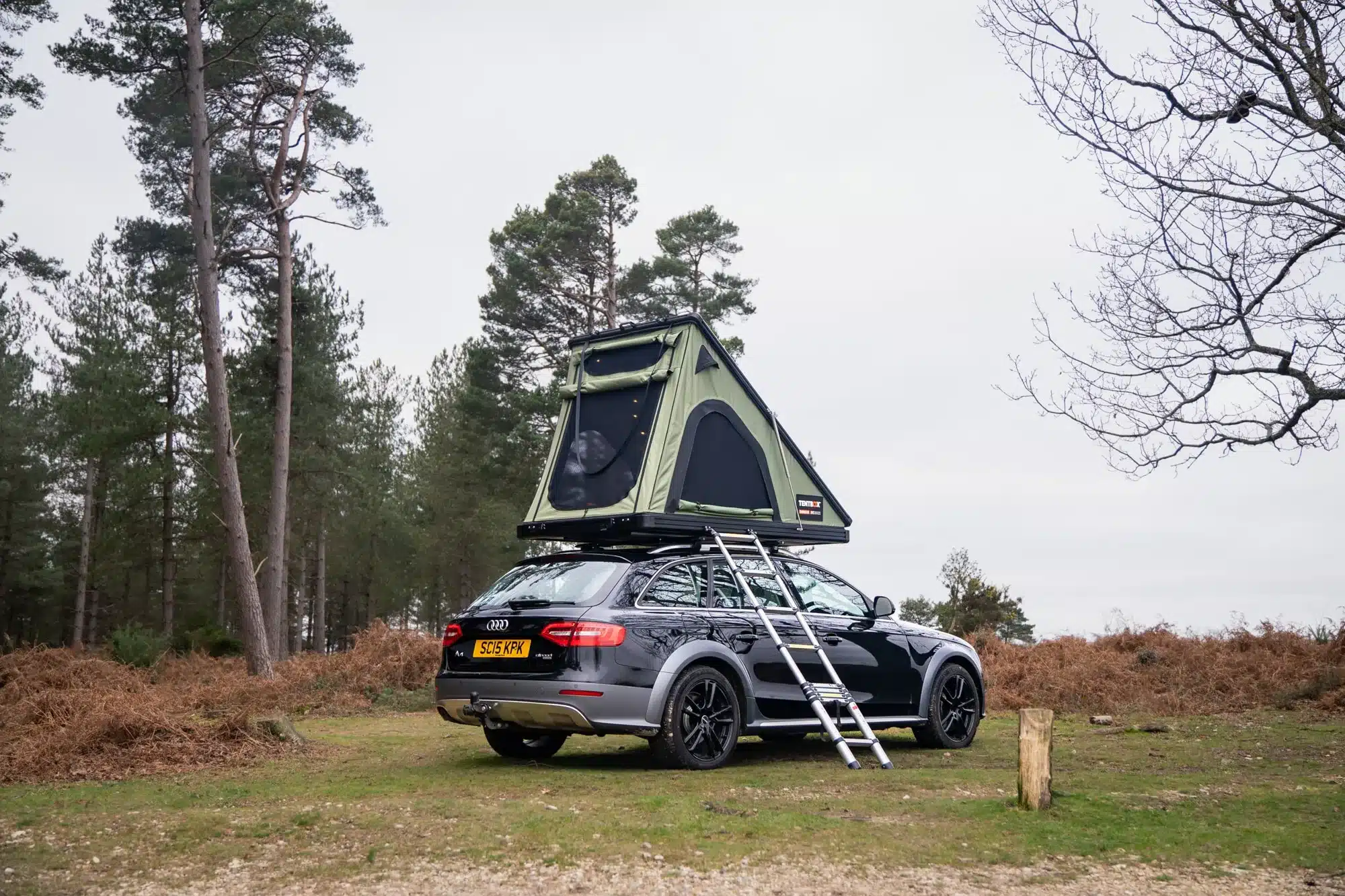 Auto mit aufgeklapptem TentBox Cargo 2.0 Dachzelt und Leiter im Freien
