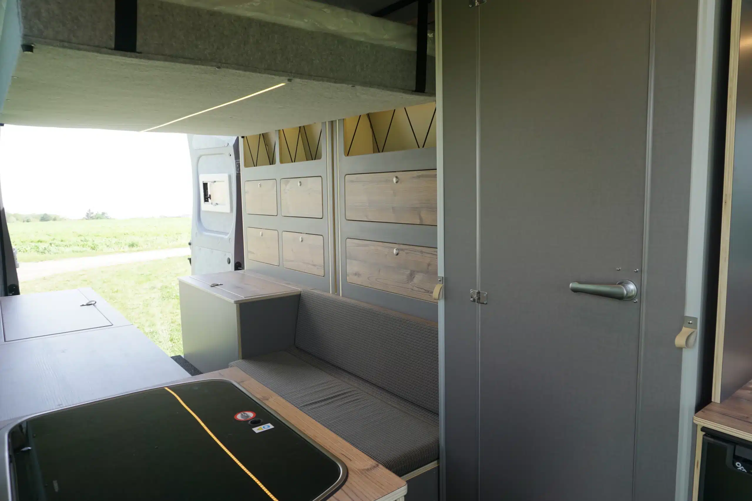 Innenansicht des TIPI XL Kastenwagens mit Sitzbank, Schränken und modernem Ausbau