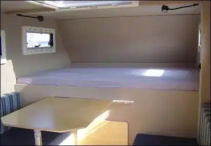 Innenraum des Toyota HZJ 79 mit Alkovenbett, Sitzdinette und Tisch