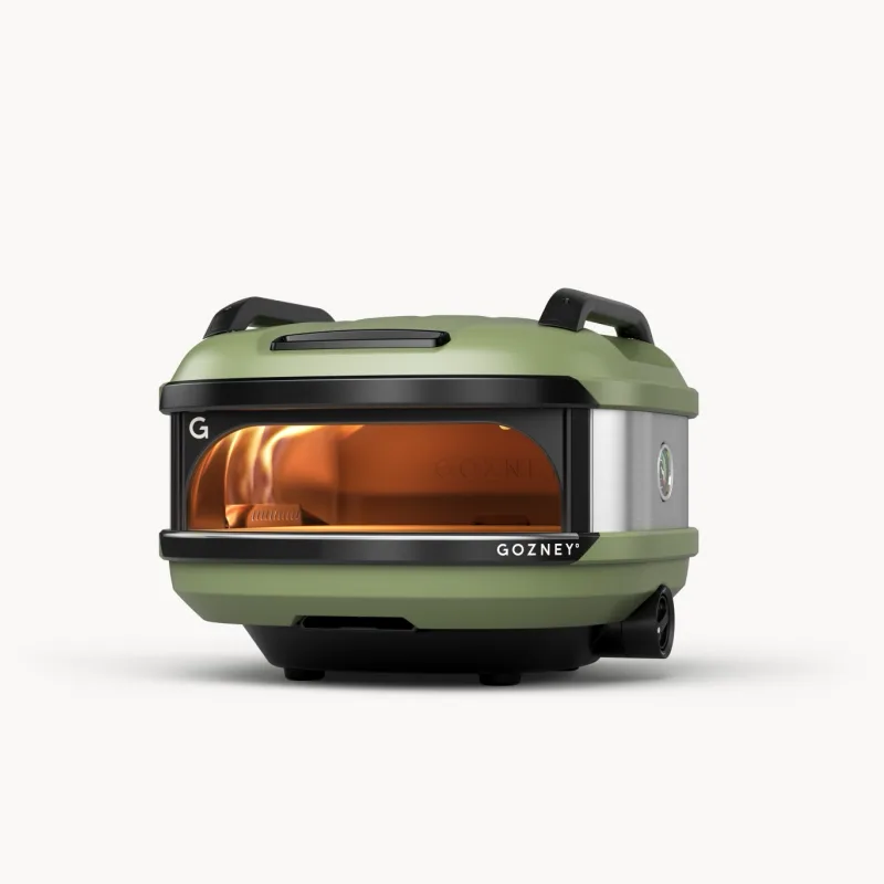 Mobiler Pizzaofen Tread in Grün mit seitlicher Flamme, ideal für Camping und Vanlife.