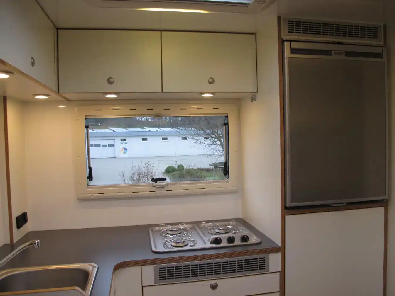 Innenraum eines Unimog 435 Expeditionsmobils mit Küchenzeile, Gasherd, Spüle und Kühlschrank.