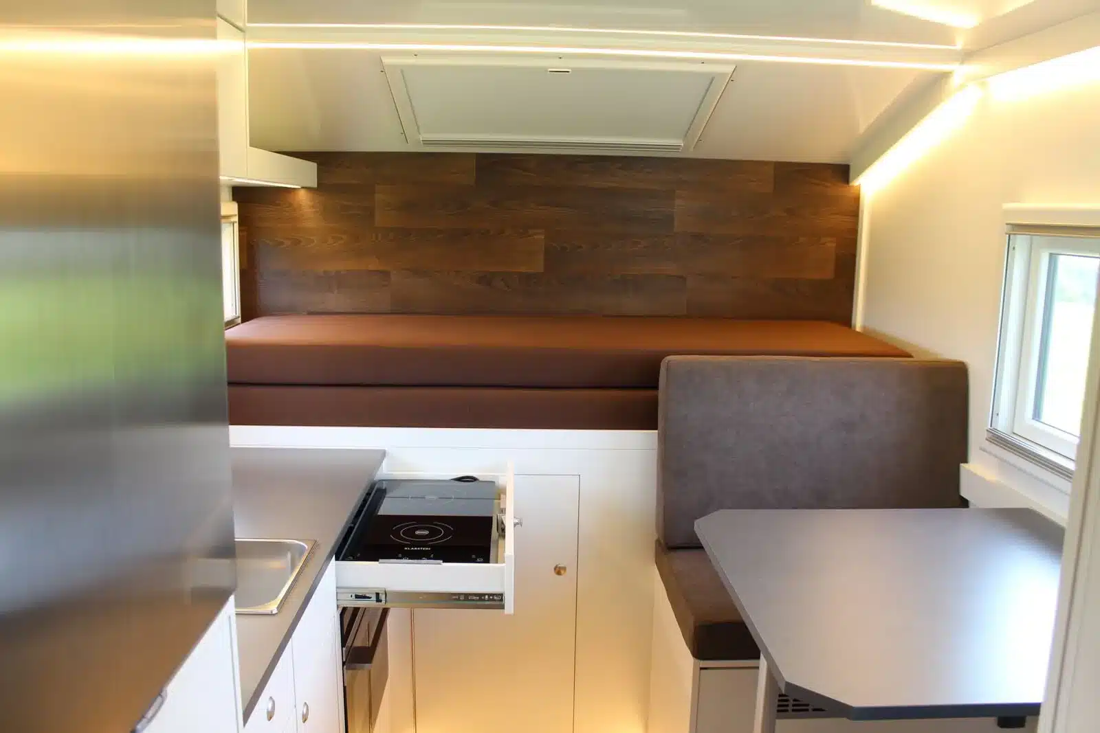Innenansicht eines Unimog U1550L mit Woelcke Wohnkabine, Auszugsbett, Sitzgruppe und Küchenmodul