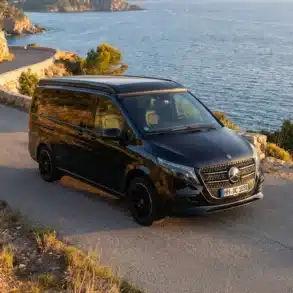 Schwarzer Mercedes V-Klasse Expedition Campervan auf einer Straße direkt am Meer