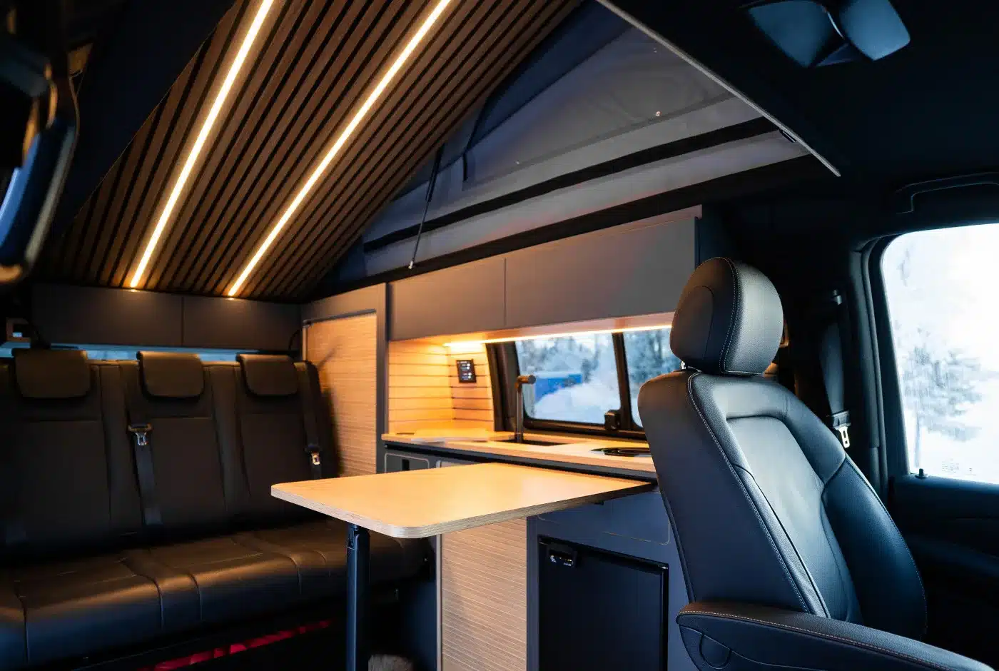 Innenraum der Mercedes V-Klasse Expedition mit hochwertiger Ausstattung, flexibler Sitzgruppe und kompakter Küche.