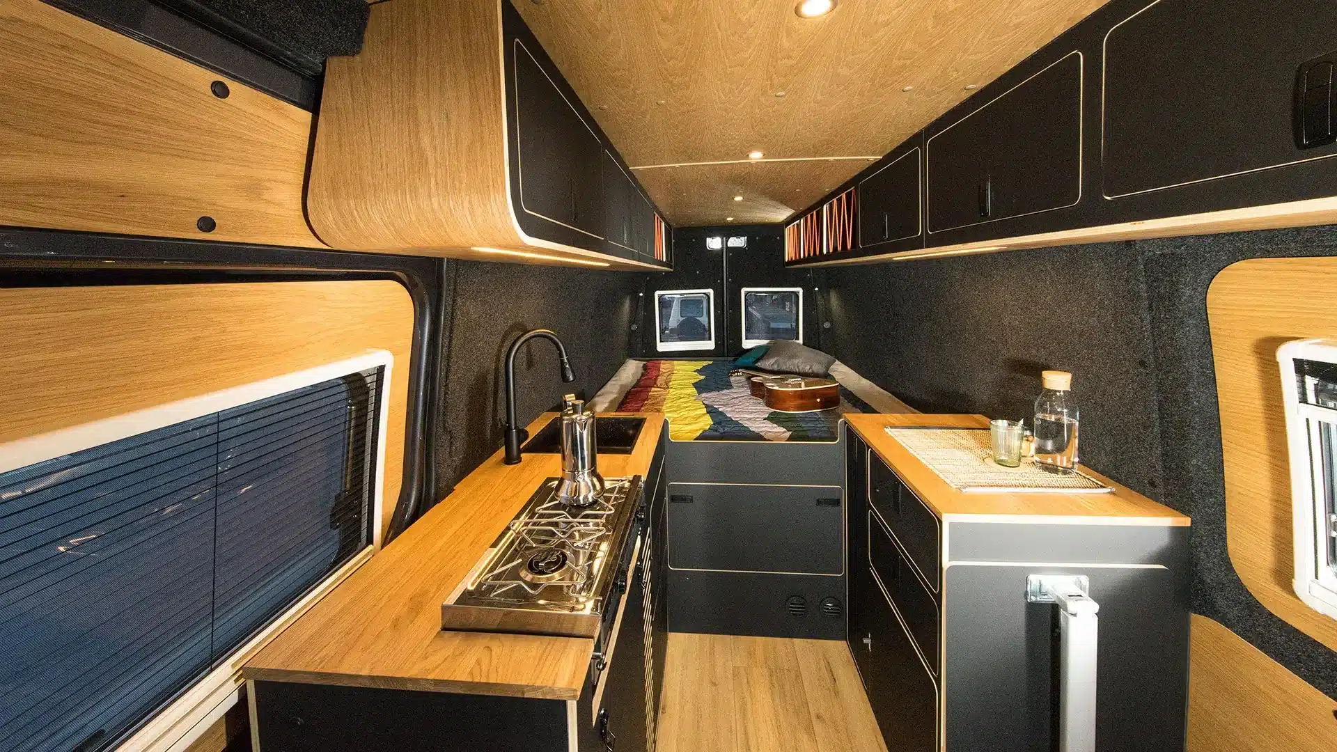 Innenansicht eines hochwertig ausgebauten Kastenwagens Van in Black mit dunklem Design und Echtholzelementen